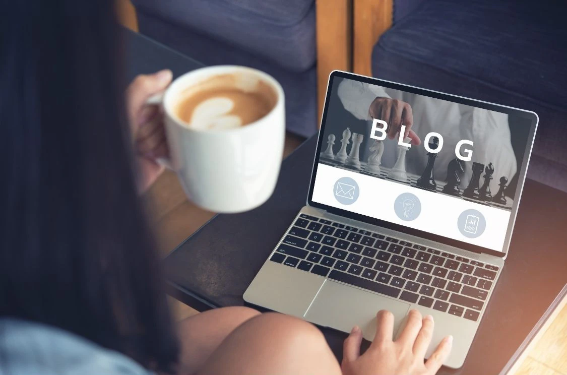 Femme qui rédige un article de blog sur un ordinateur portable.